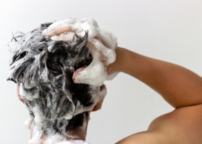 Mężczyzna myjący włosy dba o ich kondycję używając dobrych kosmetyków