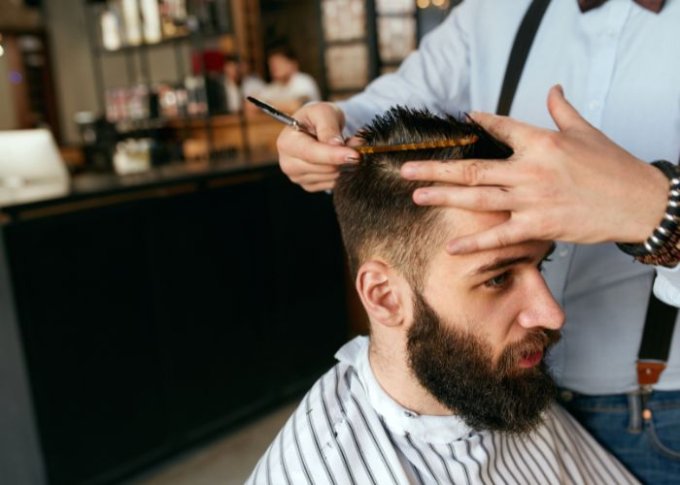 Mężczyzna u fryzjera ścina włosy