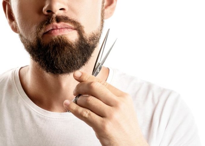 Mężczyzna uczy się samodzielnie przycinać sobie brodę