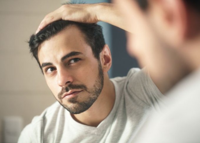 Mężczyzna zauważa u siebie pierwsze oznaki łysienia